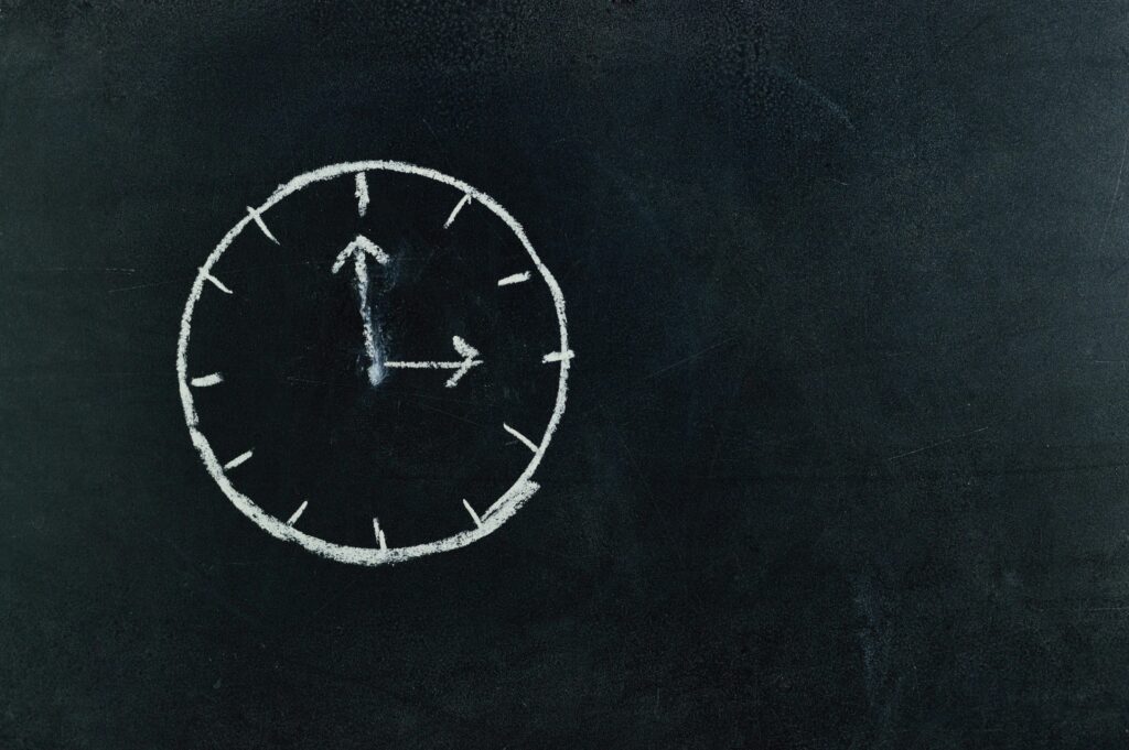 pexels-photo-745365-745365 Chalk-drawn clock on a blackboard, symbolizing time and education concepts.